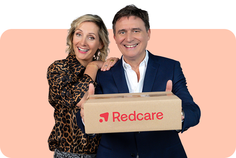 Een glimlachende vrouw legt haar hand op de schouder van een man die een pakket met het Redcare-logo vasthoudt.